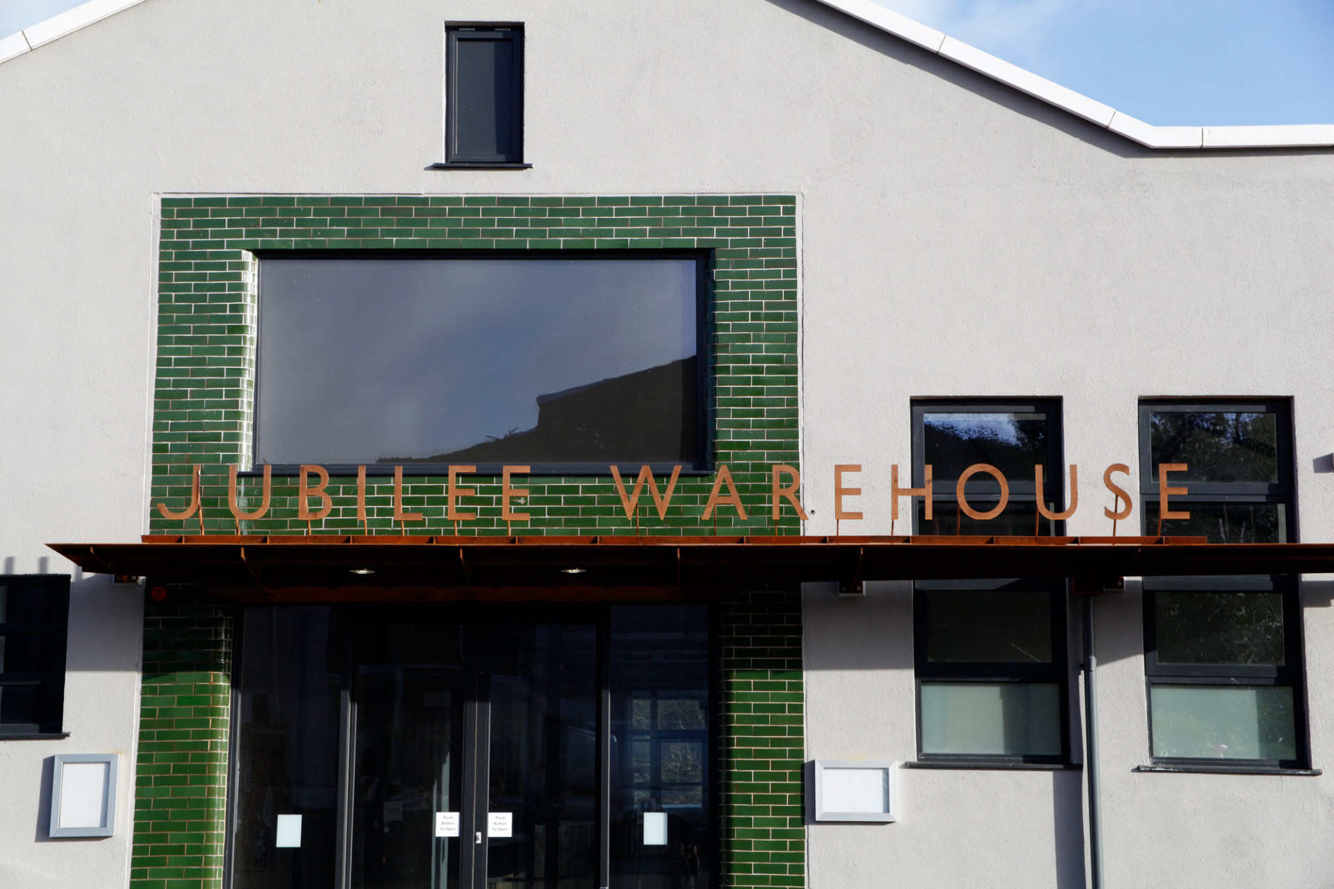 Corten Jubilee Warehouse sign and handmade green bricks around the front door.